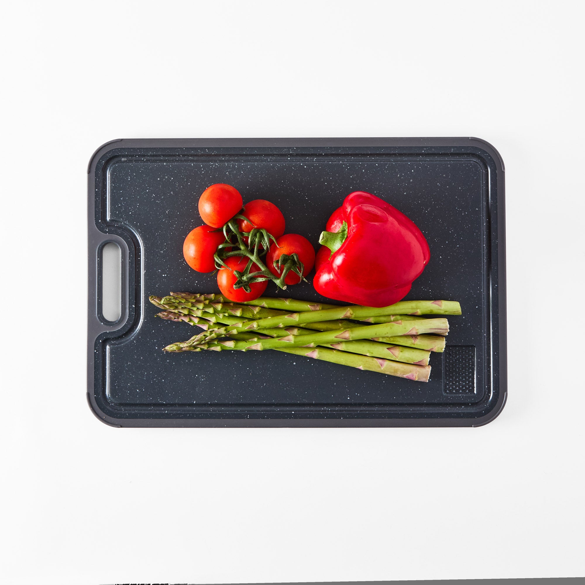 Polypropylene side of the chopping board with fresh vegetables