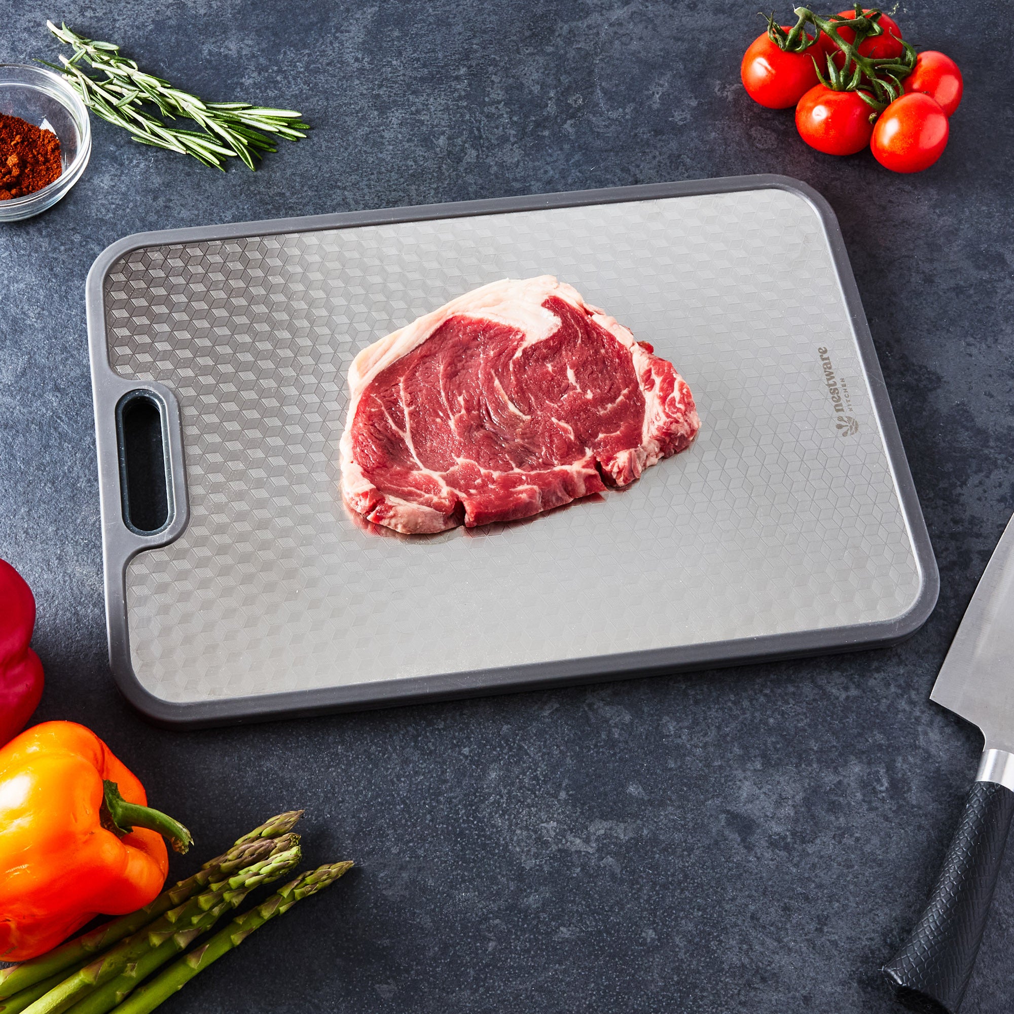 Steak resting on the stainless steel side of the board